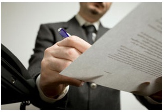 Fotografía de una persona firmando un documento.